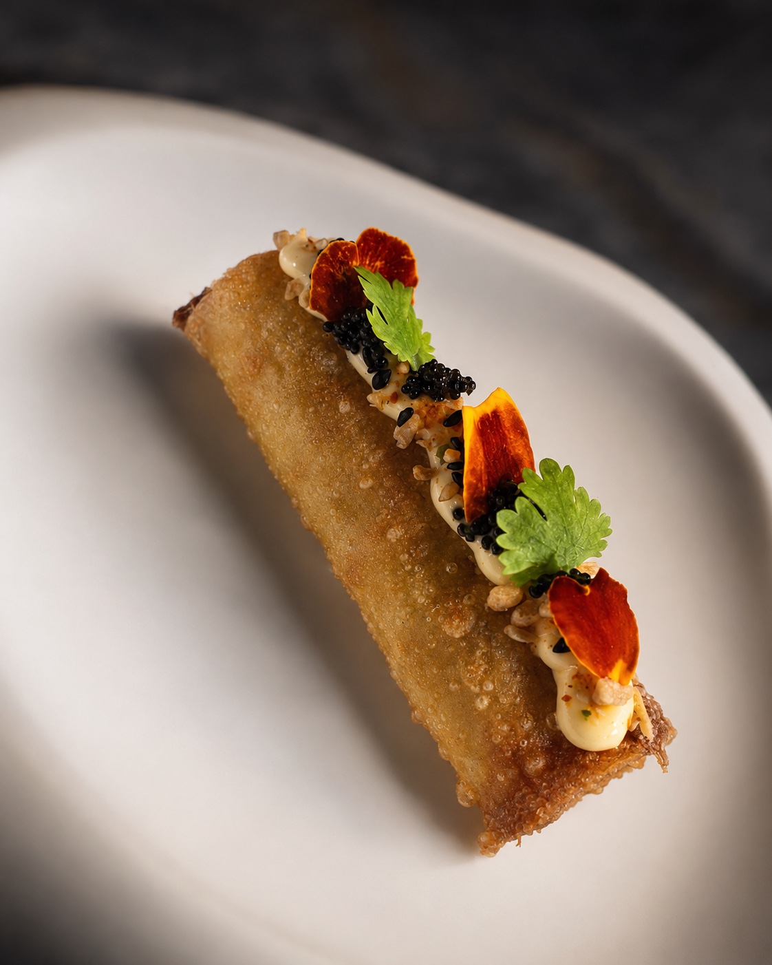 A refined crispy course garnished with caviar and herbs